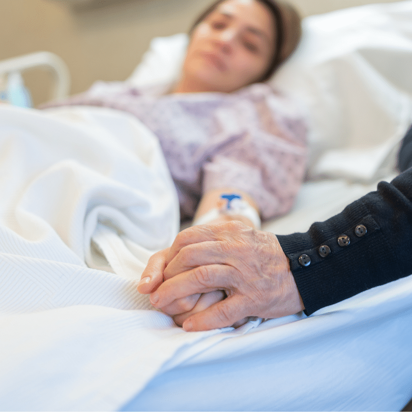 a imagem mostra uma mulher em leito do hospital de maos dadas com um acompanhante